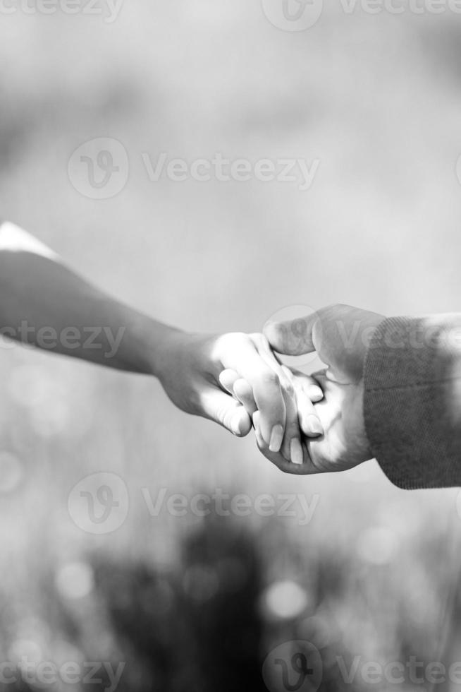 La novia abraza al novio y sostiene un ramo de novia con flores azules en el fondo del bosque foto