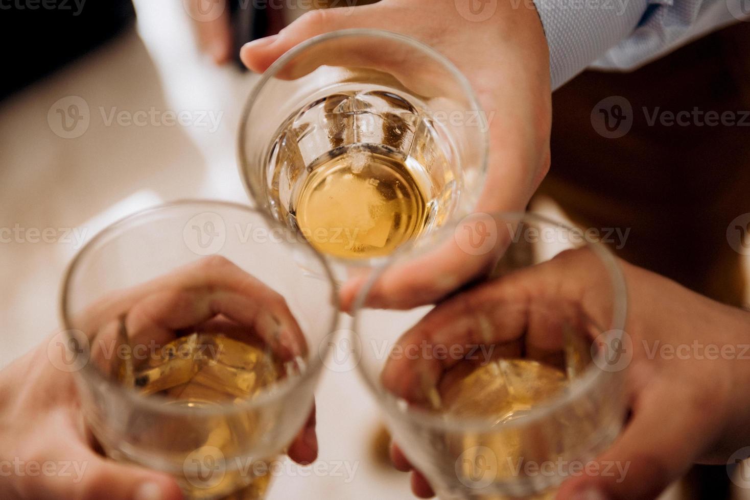 vasos en el marco, tostadas y manos de la gente foto