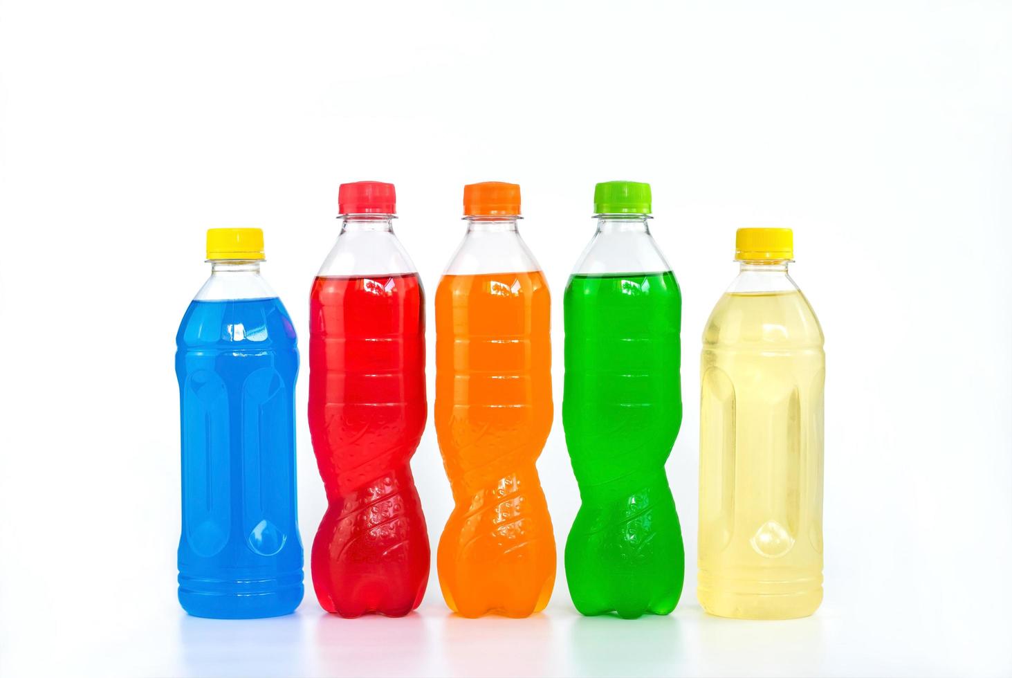 Multi colored drinks in plastic bottles on white background photo