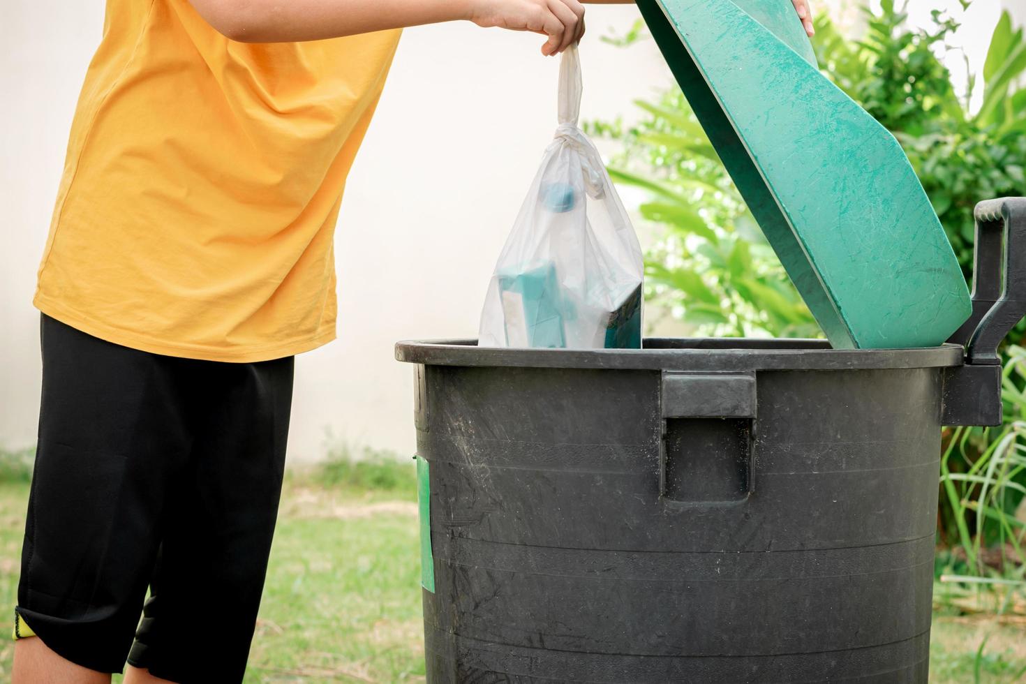 Throw trash in plastic bags into the trash photo