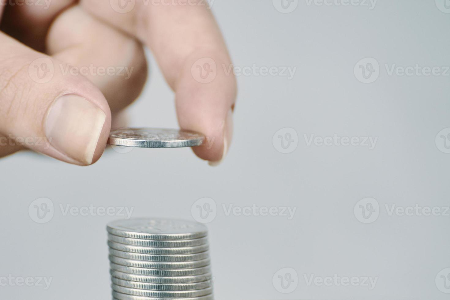 La mano de la mujer puso monedas de plata para apilar. foto