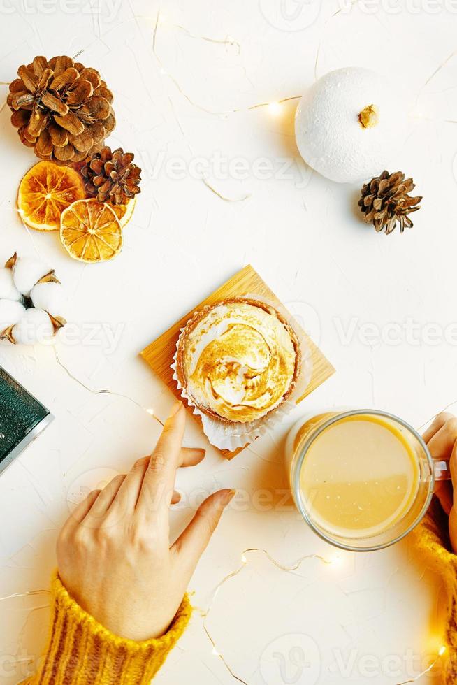 Top view of tartlet, coffee and decorations on white table. photo