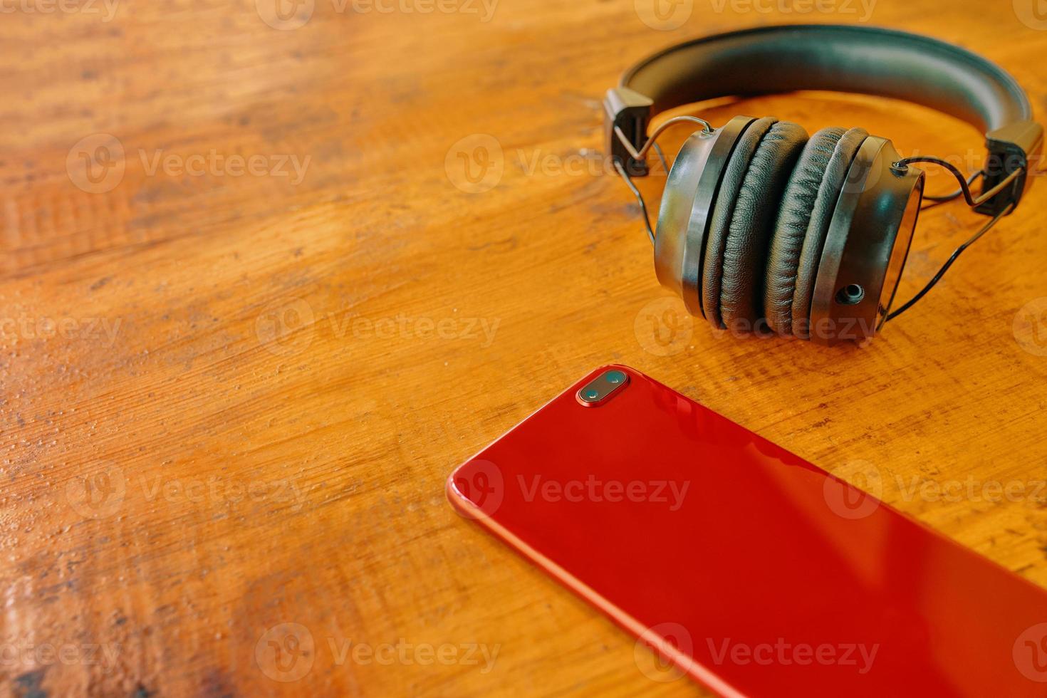 Headphones and smartphone on wooden table. photo