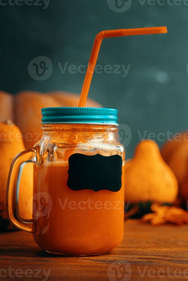 jugo de calabazas en botellas con calabazas. foto