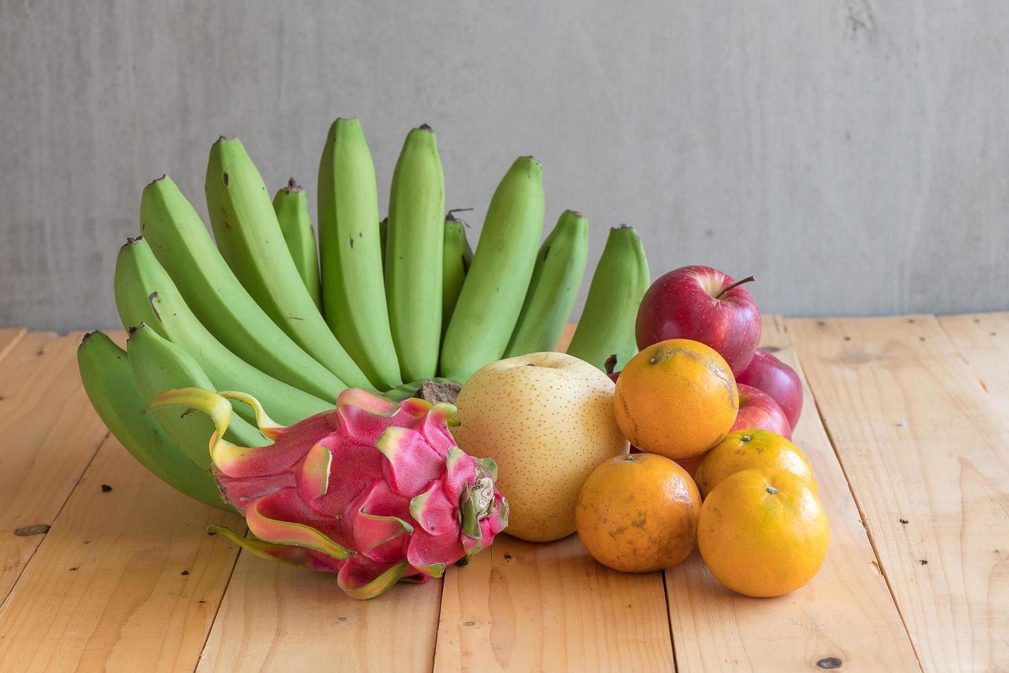 concepto de dieta de frutas. diferentes frutas en la mesa de madera foto