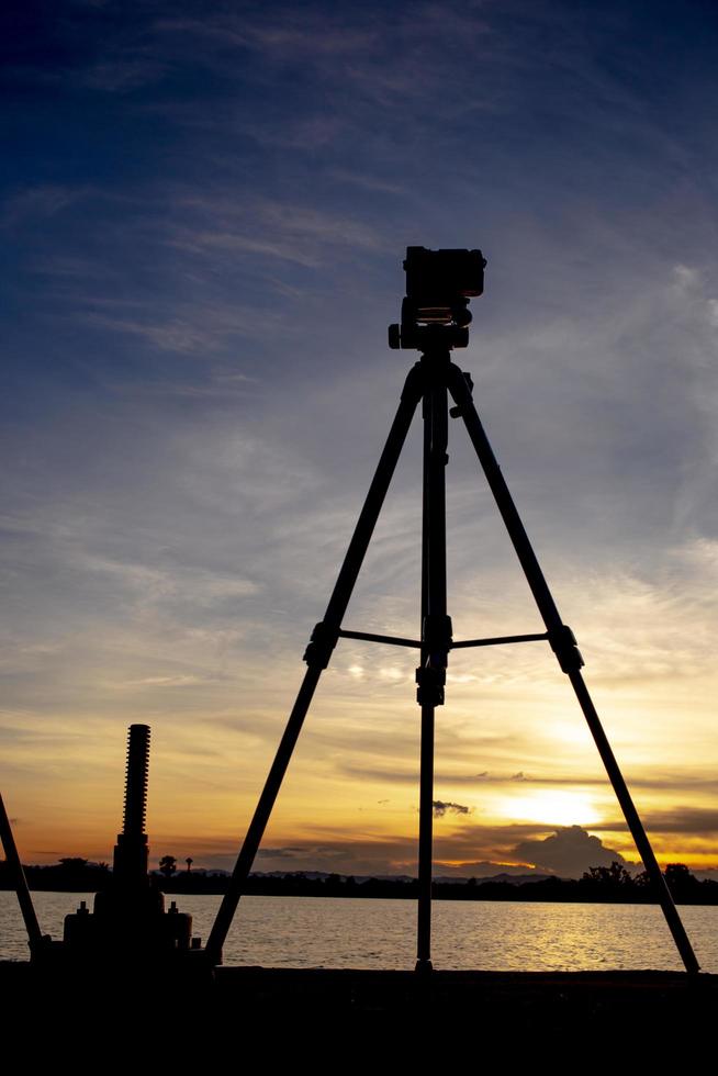 Silhouette of a camera and tripod at sunset stock photo