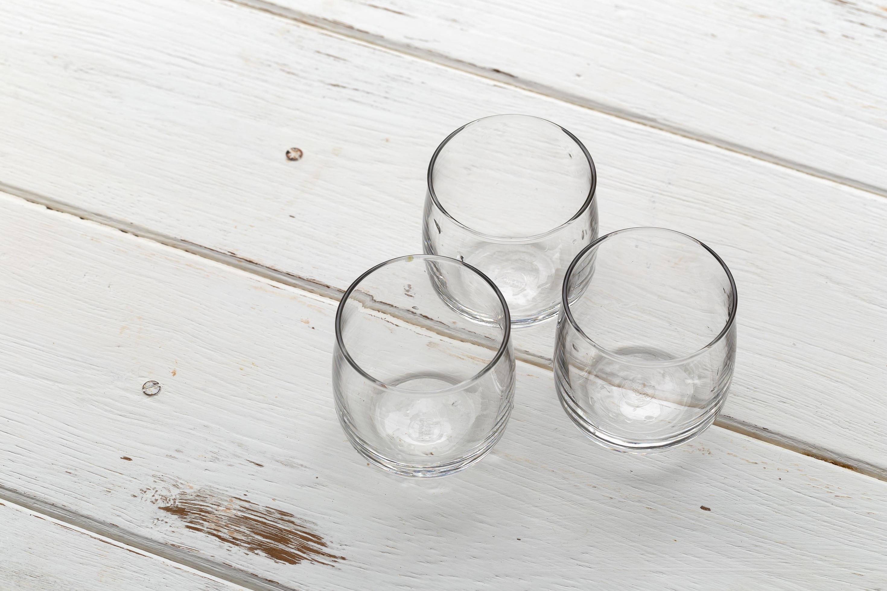 Tres vasos vacíos en una mesa de madera blanca foto