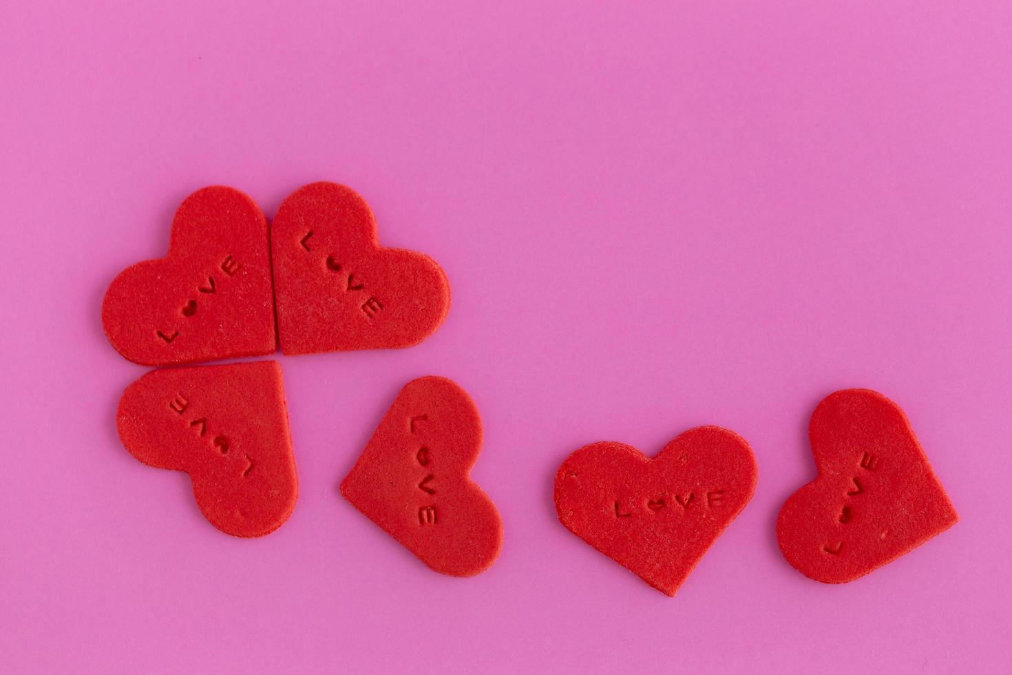 Red heart shaped sugar on pink background photo