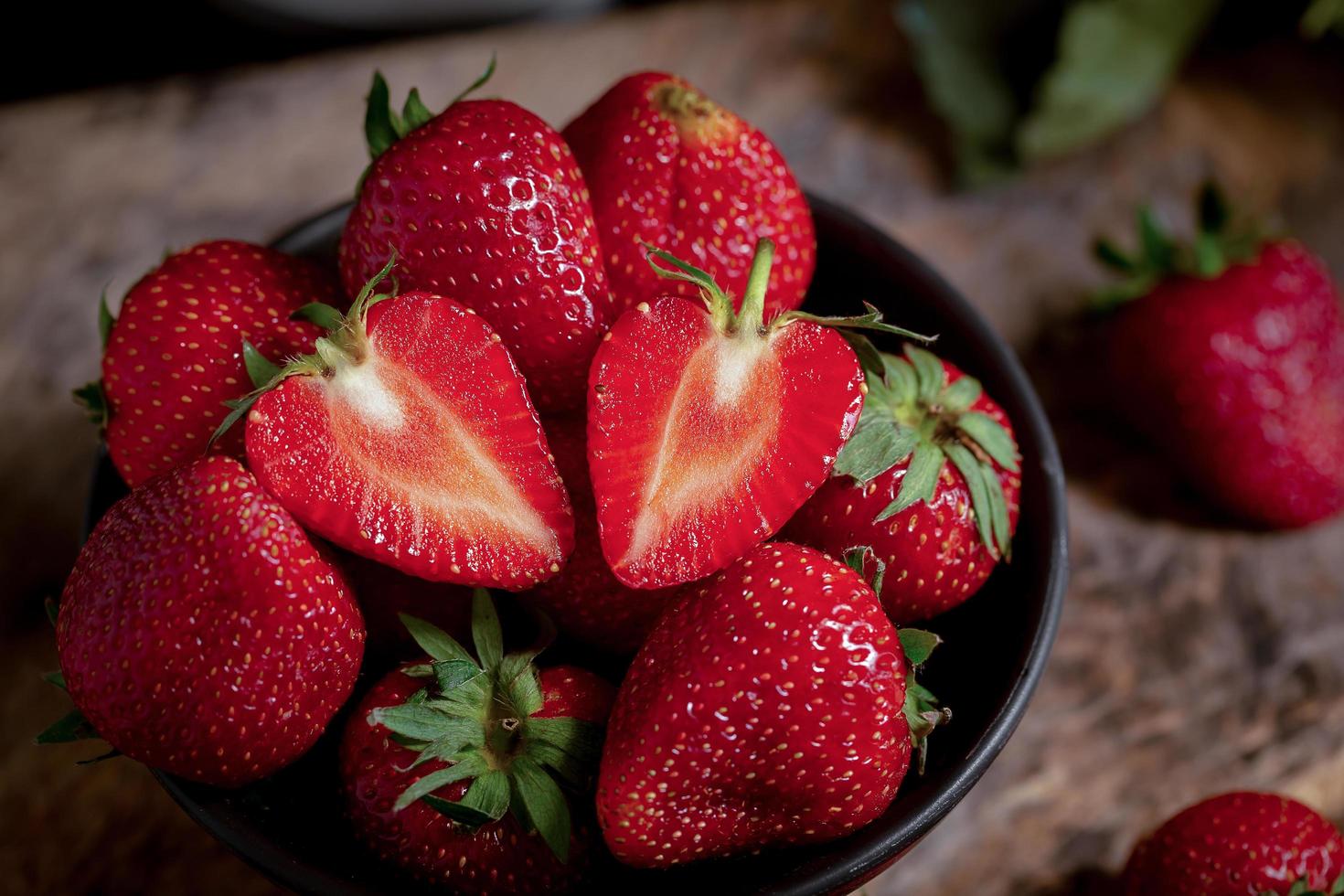 Ripe red strawberries on black wooden table photo