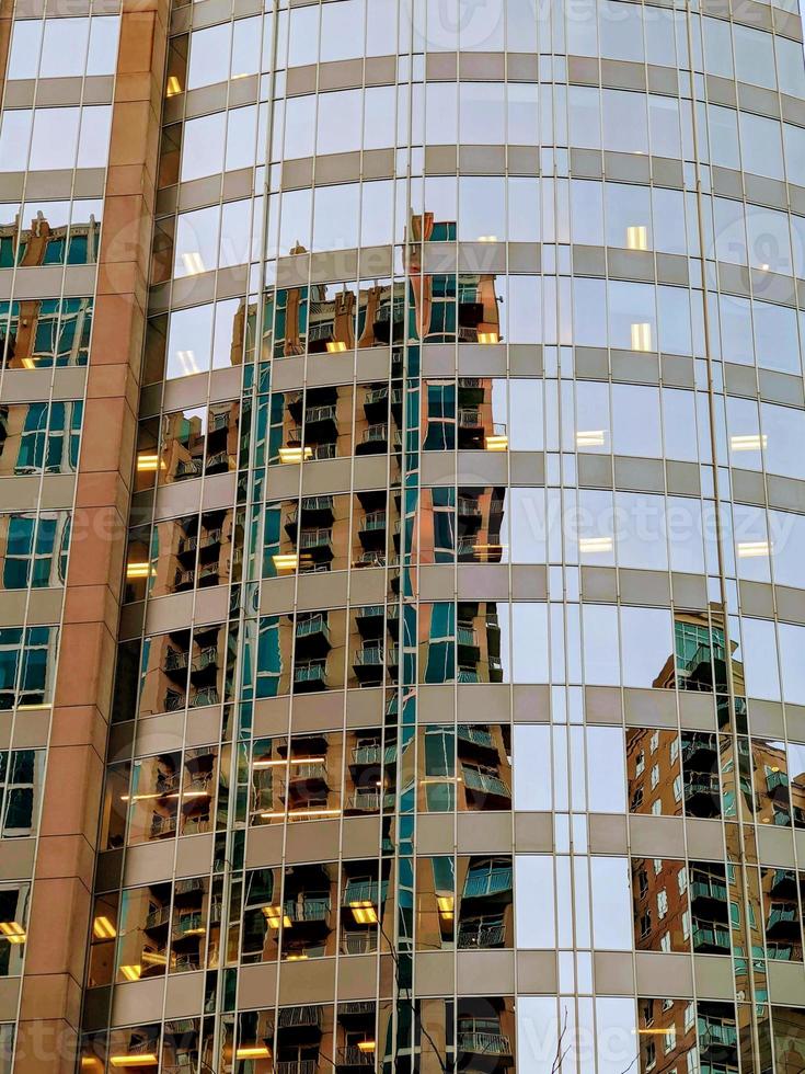 Facade of modern glass building with reflections of blue sky photo