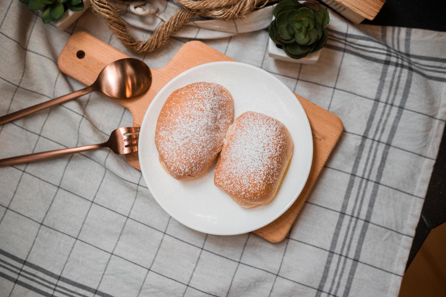 Soft butter bun with icing sugar on a wooden plate photo