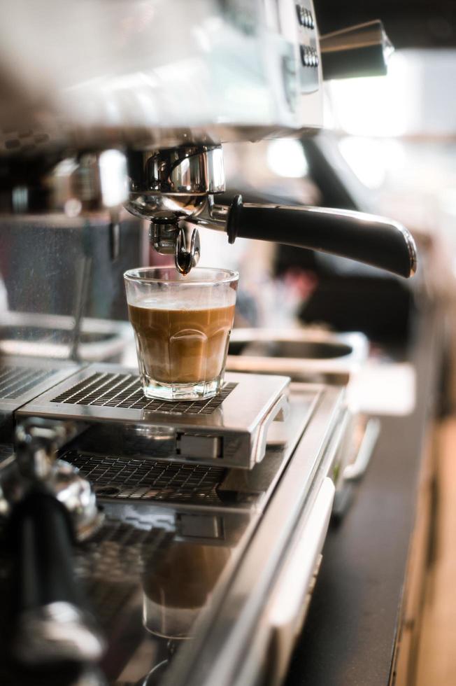 Black coffee with milk on coffee maker photo