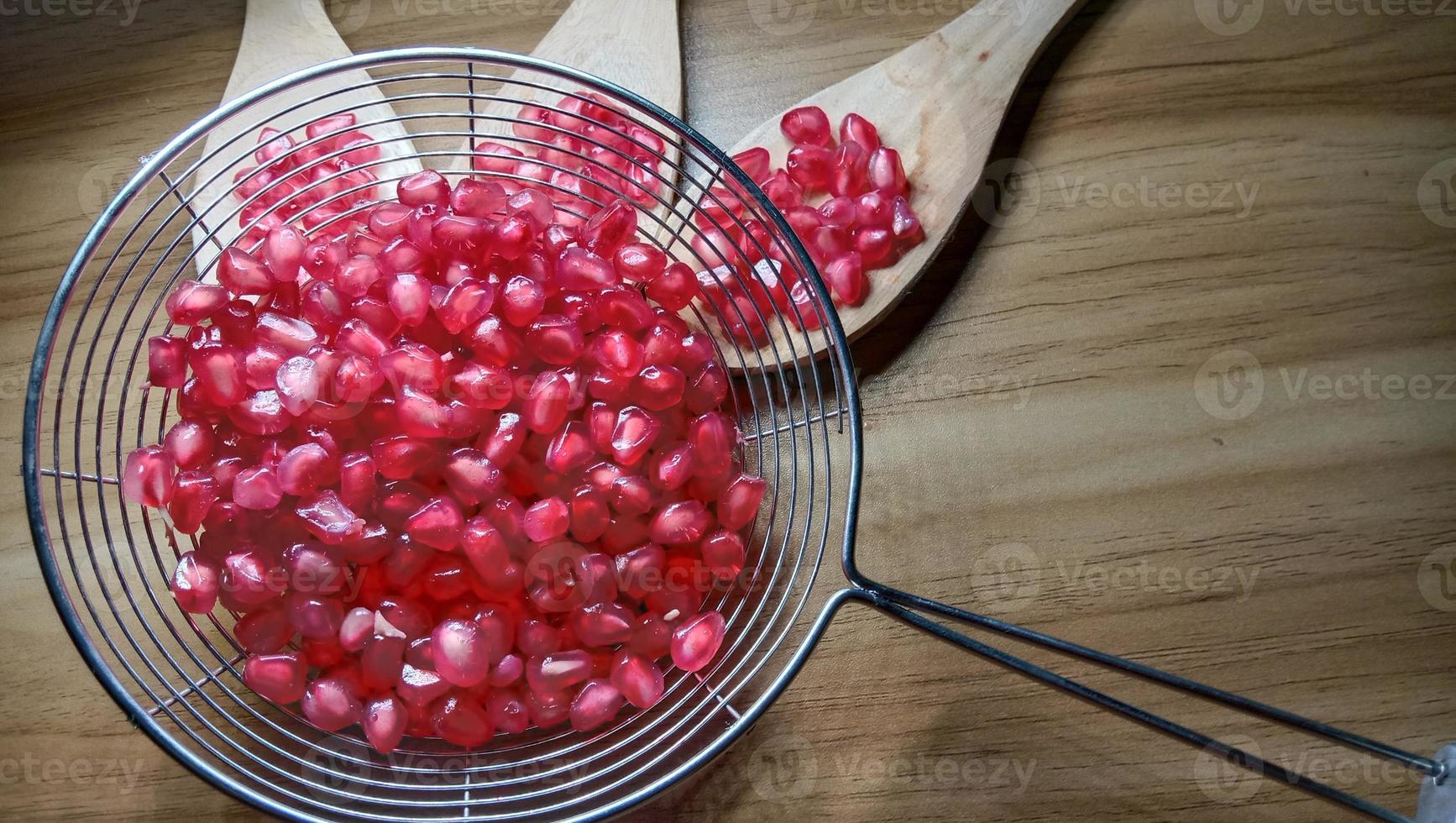 pomegranate seeds stock on net spoon photo