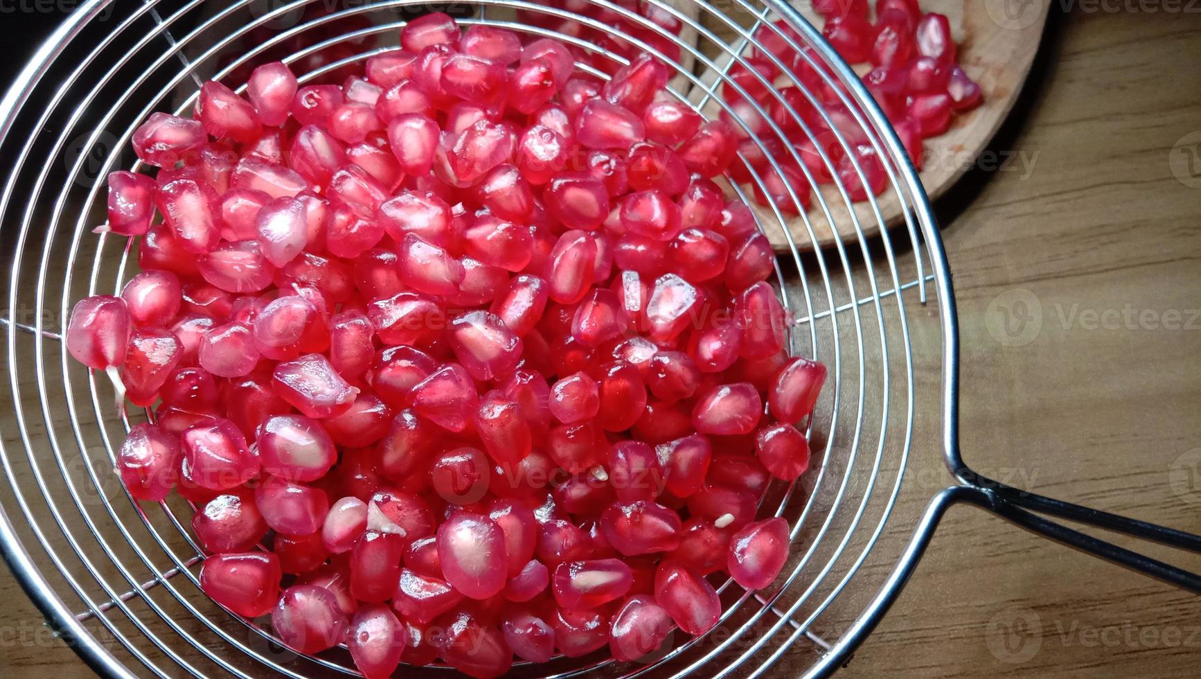 pomegranate seeds stock on net spoon photo