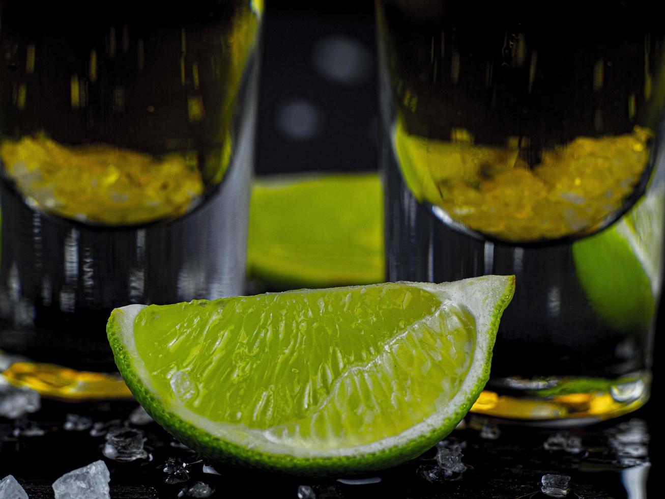 dos tragos de tequila dorado con jugosa lima y sal marina foto