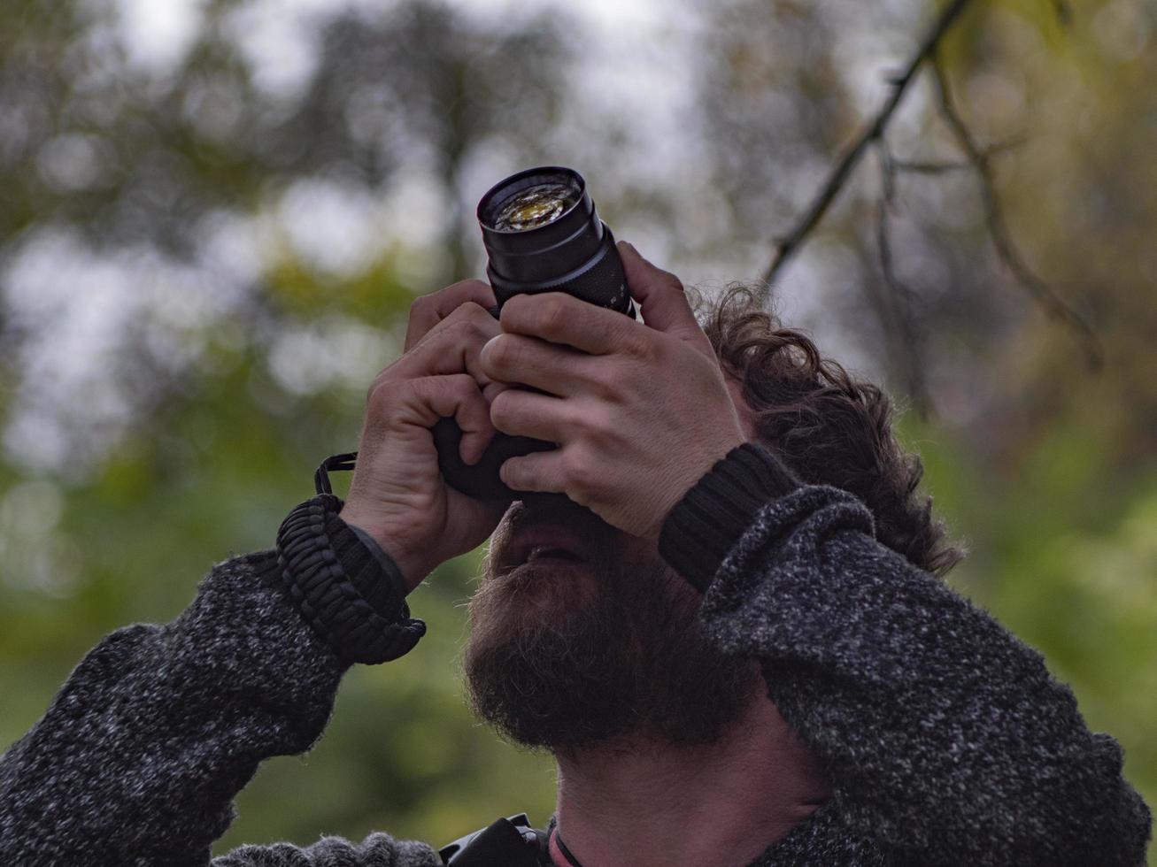 Hombre hipster barbudo hace foto en cámara