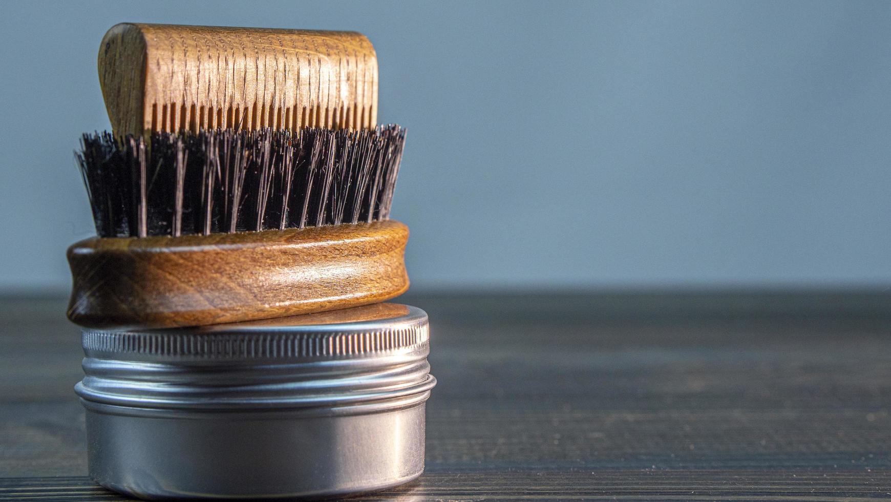 cepillo para barba, peine de madera para barba y tarro de cera foto