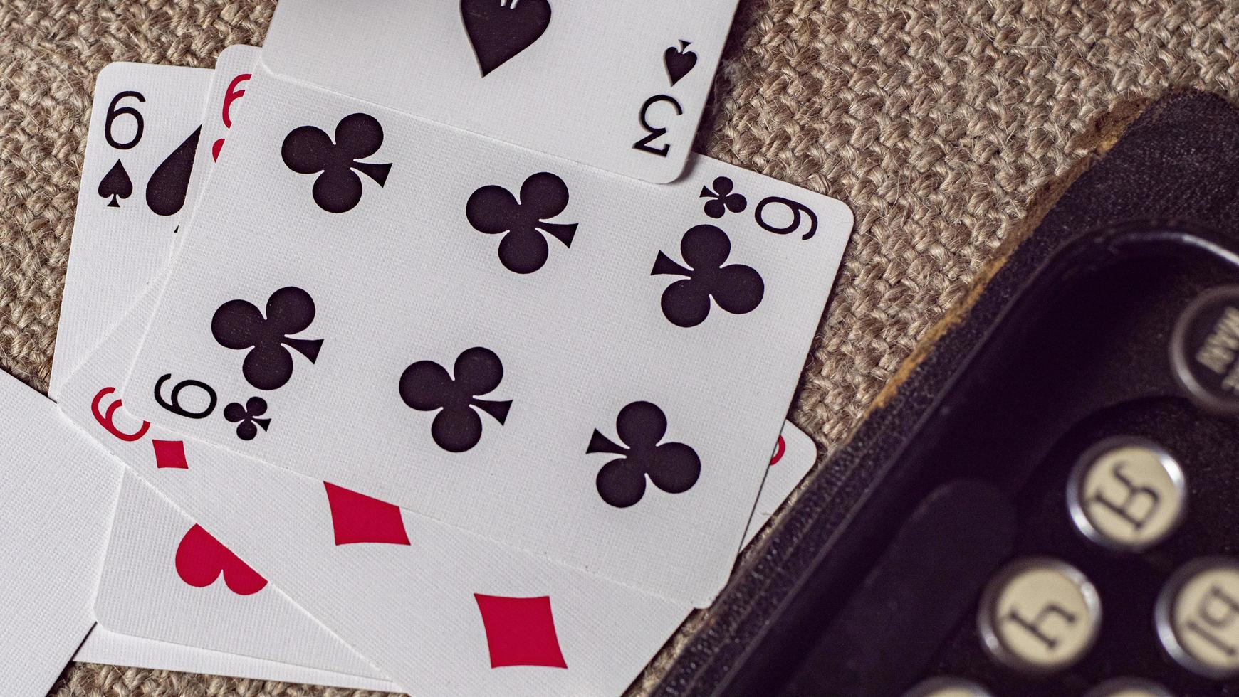 playing cards on burlap background near a typewriter. wallpaper photo