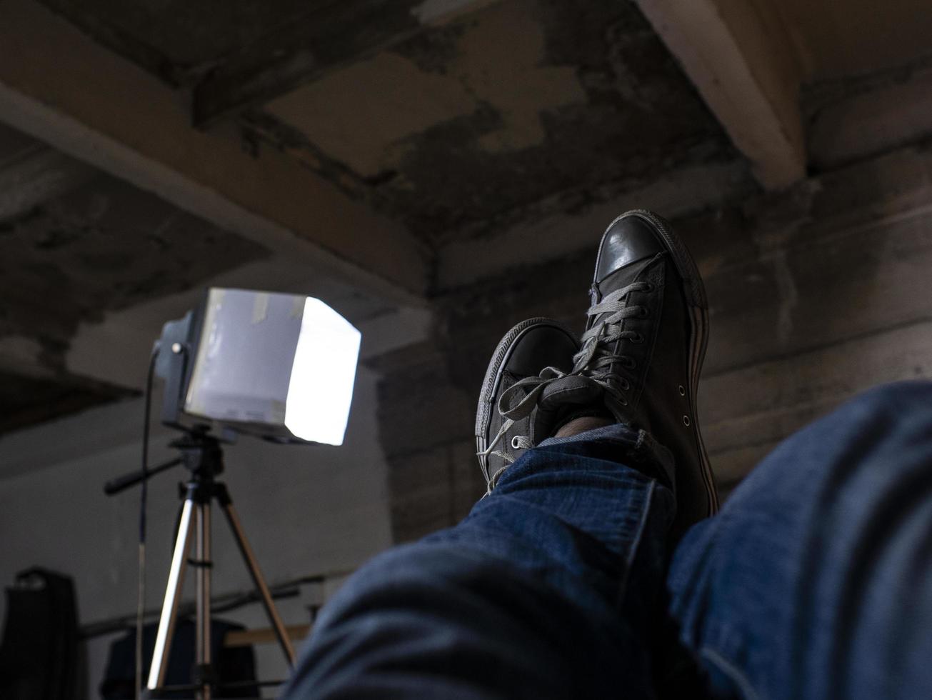 Men's feet in sneakers raised up against the ceiling photo