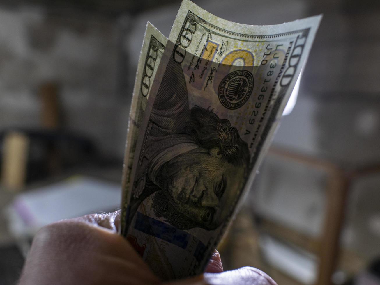 Close up of male hand holds two banknotes of hundred dollars. new hundred-dollar bills.Money USA dollar banknotes photo