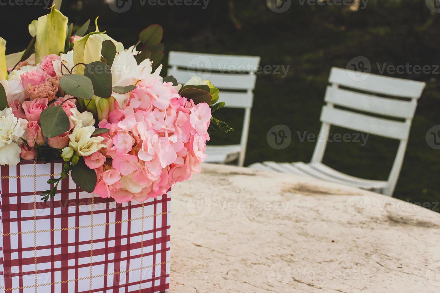 Flowers in gift box outside on table photo