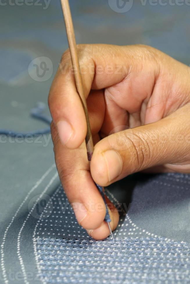 woman shoes design on cloth with hand needle photo