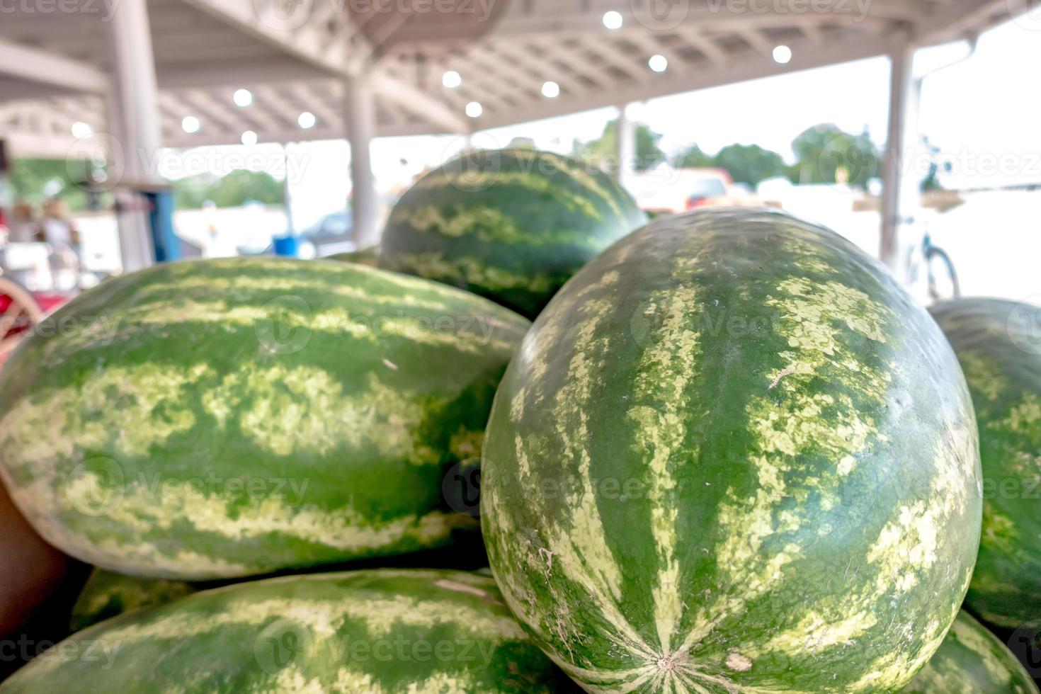 Pile of fresh ripe watermelons lying in wooden boxes in fruit photo