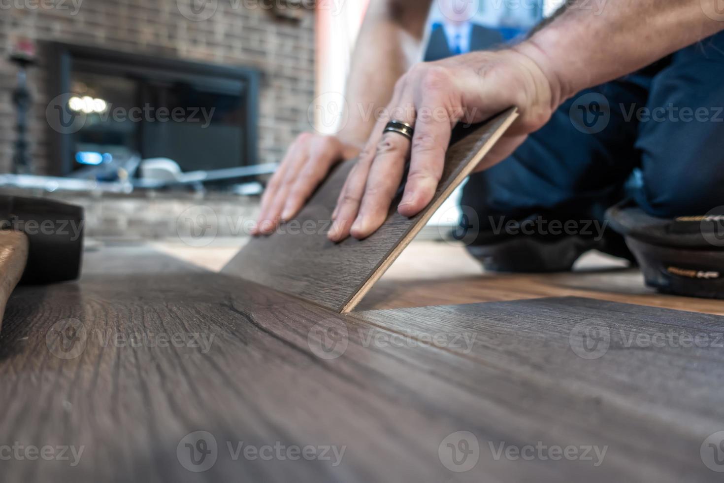 Hombre instalando madera laminada de ingeniería interior floring foto