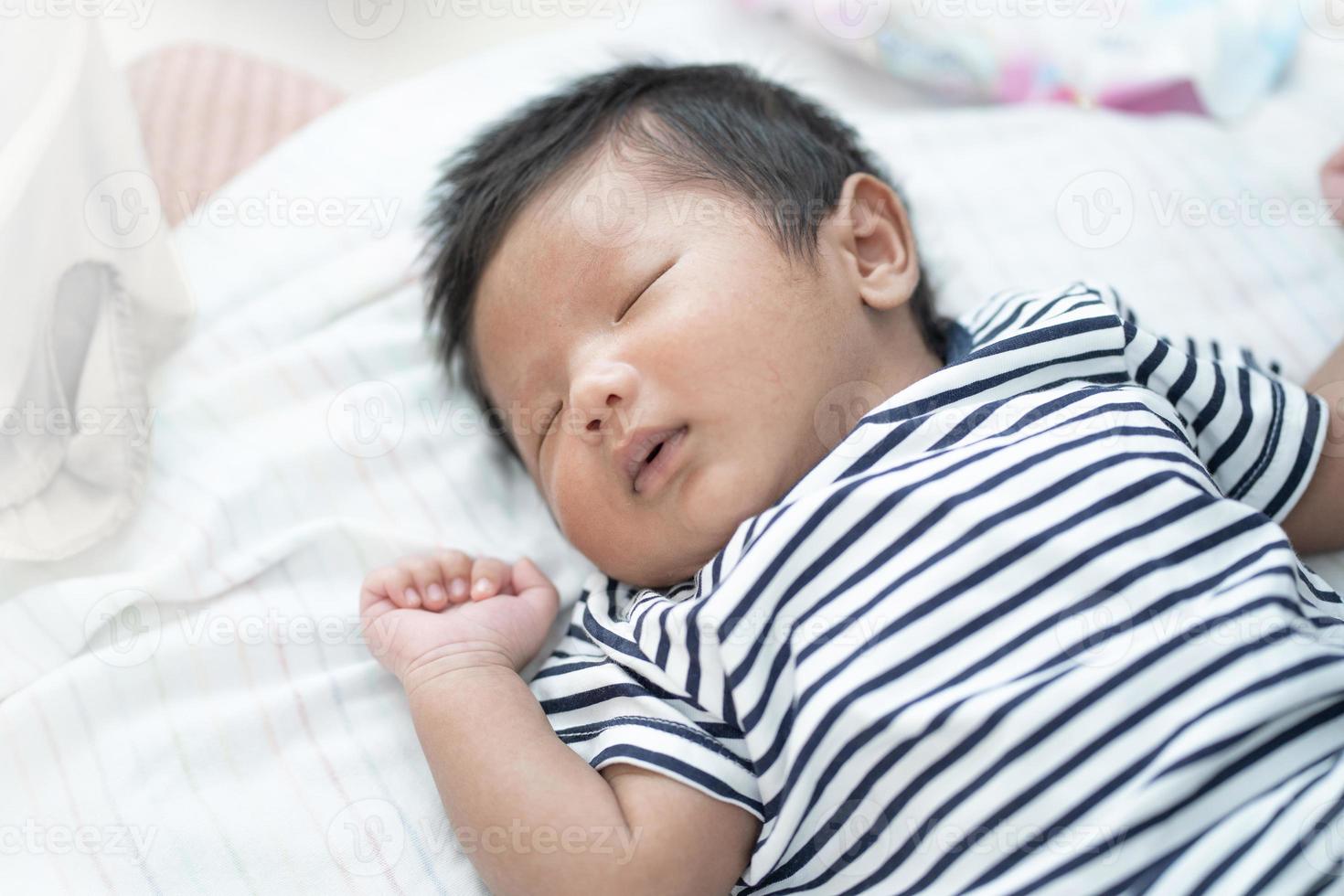 Adorable Asian sleeping, tiny infant healthy sleep with warm wool white blanket at home, baby health care concept photo