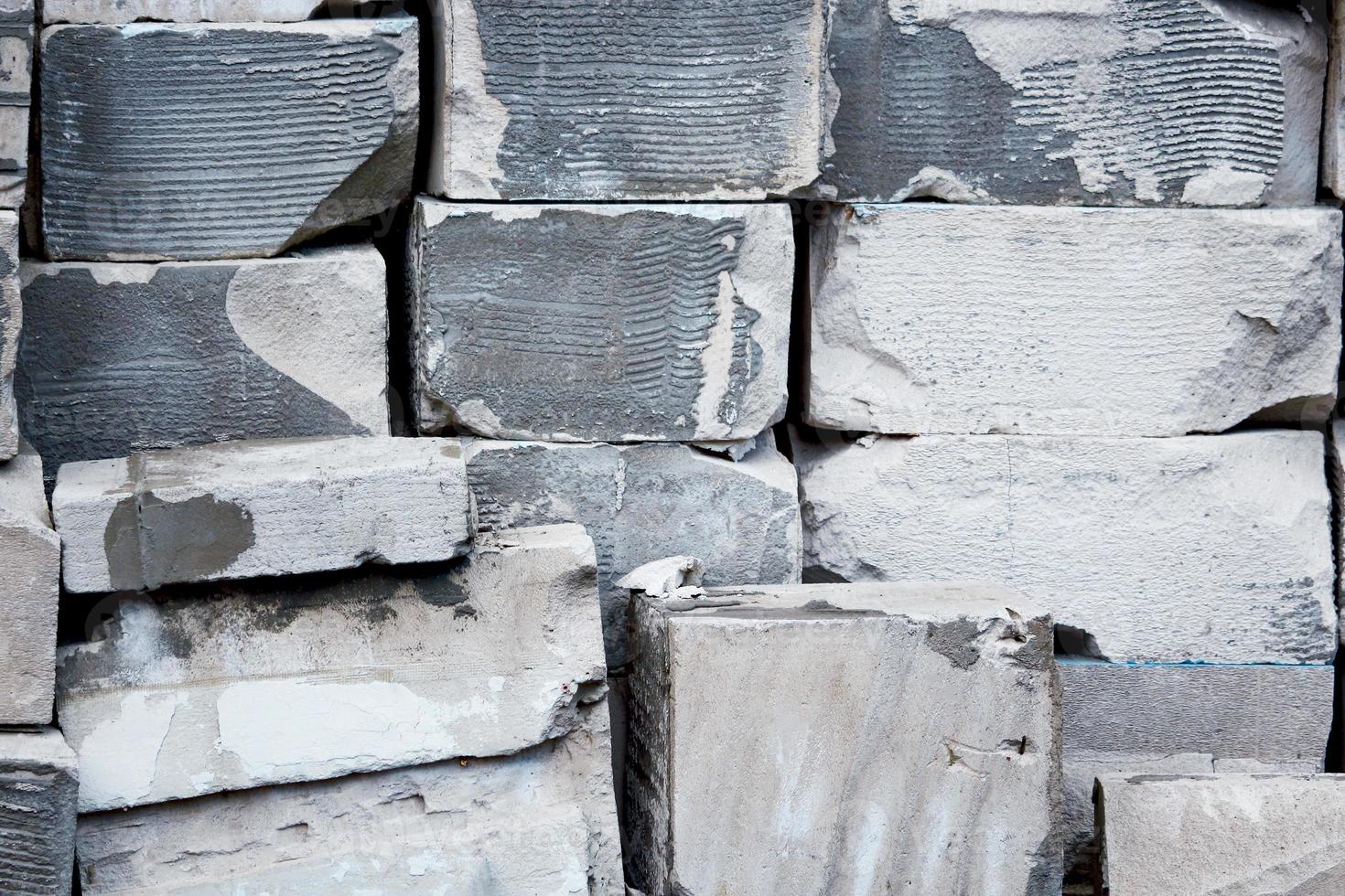 Gray and white bricks stackef like wall with gaps photo