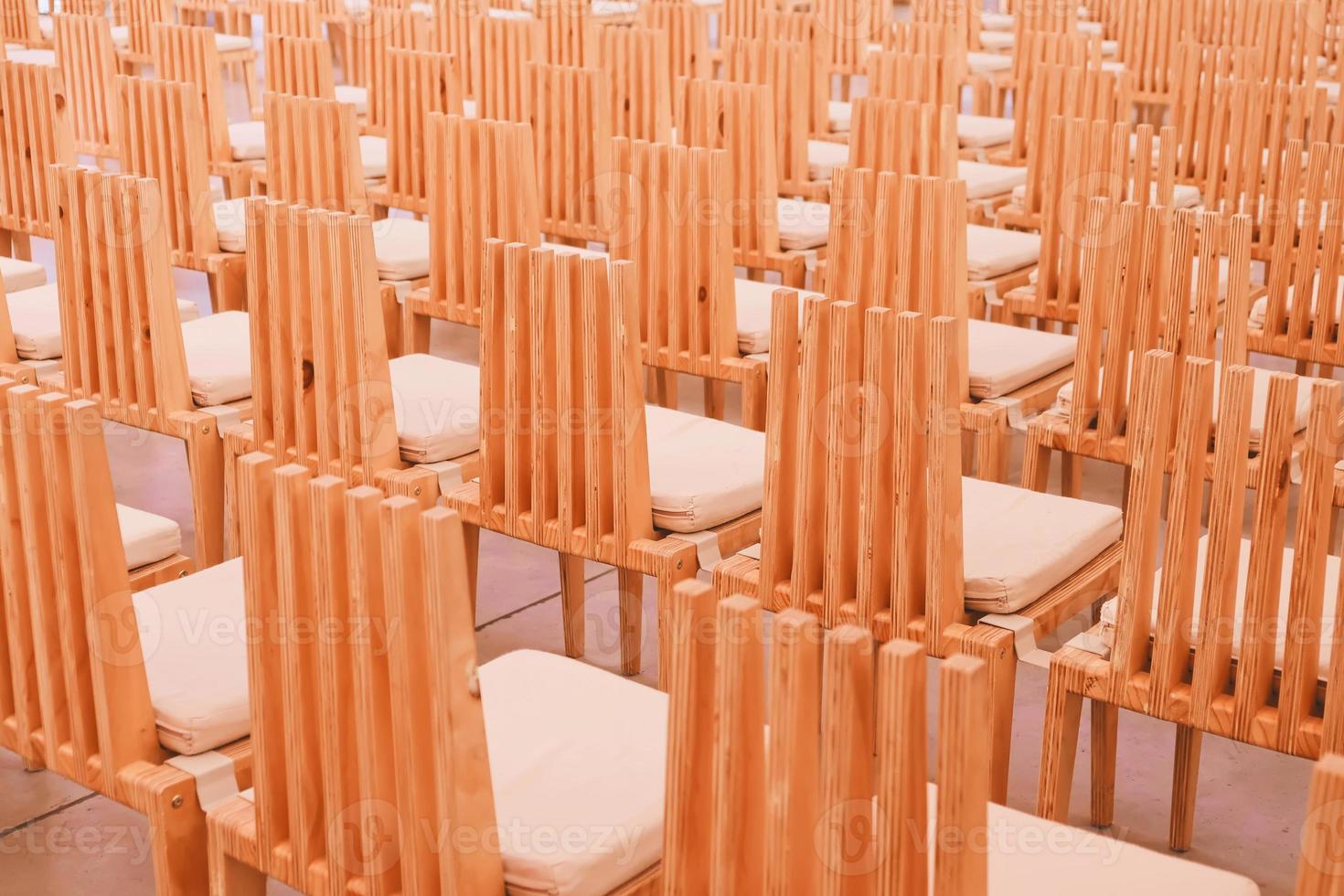 Sillas de madera en una fila en una iglesia. foto