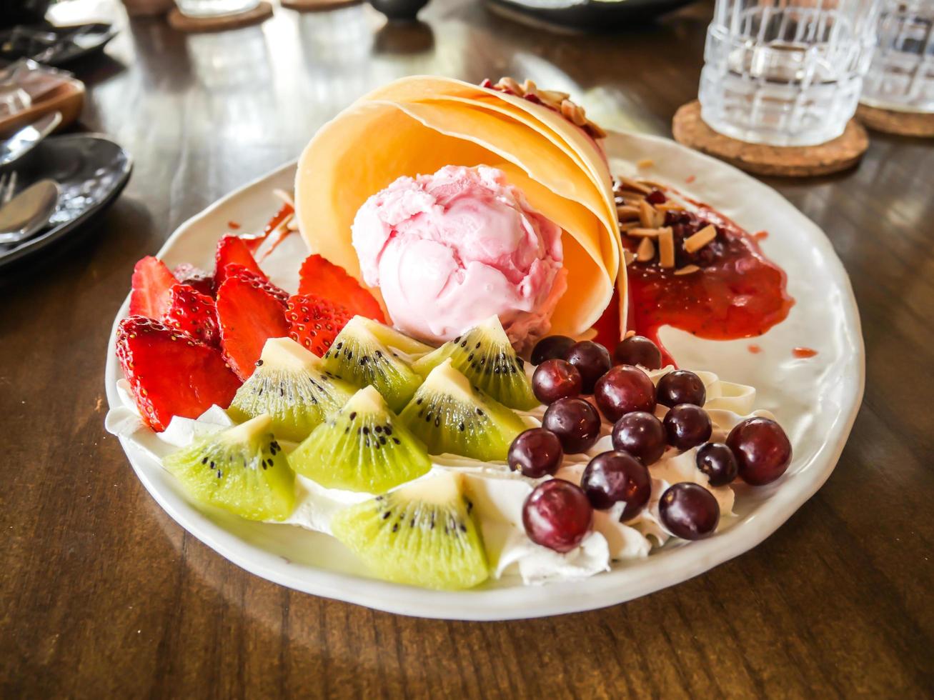 deliciosas y sabrosas crepas caseras con helado de fresa, crepas rellenas de fresas, kiwi, uva foto