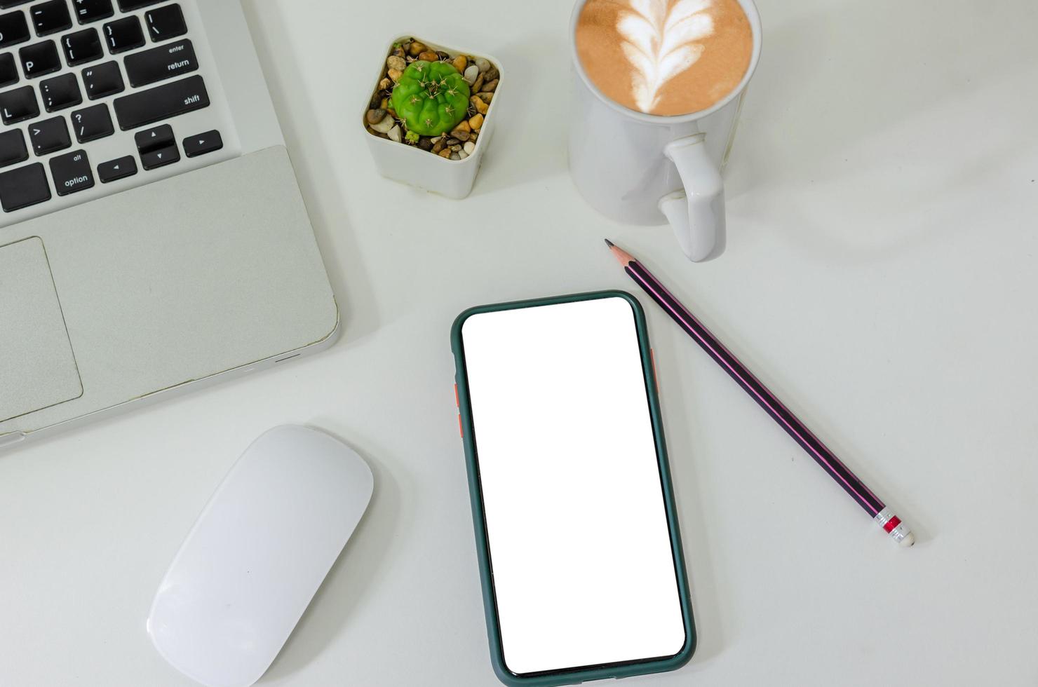 Top view mock up smart phone white blank screen and pencil coffee cup mouse computer laptop flat lay on desk photo