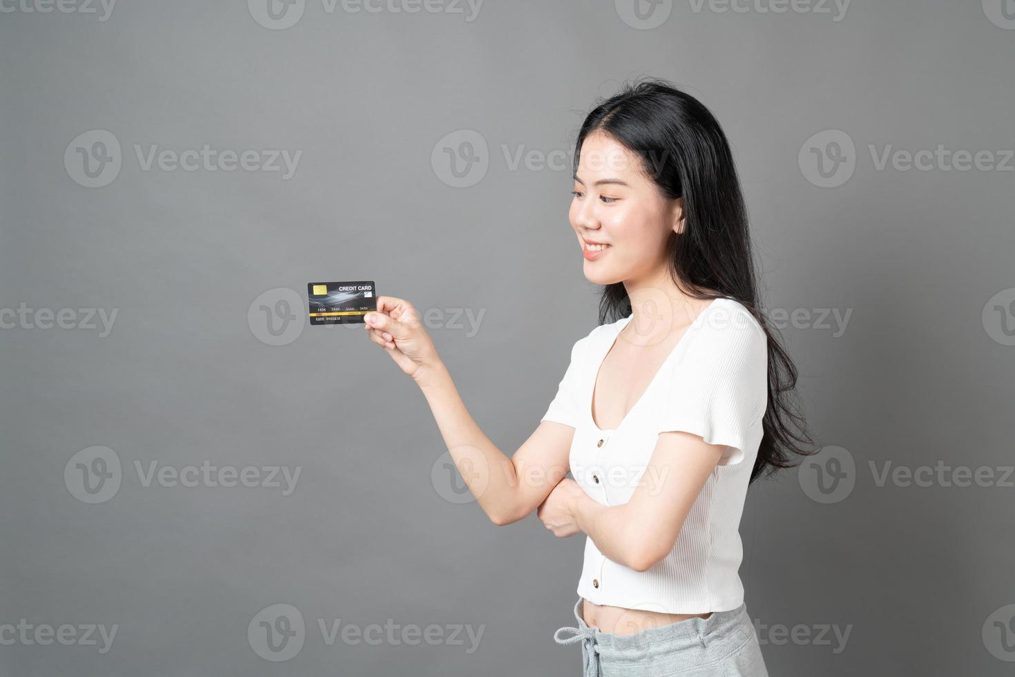 Asian woman with happy face and presenting credit card in hand showing trust and confidence for making payment photo