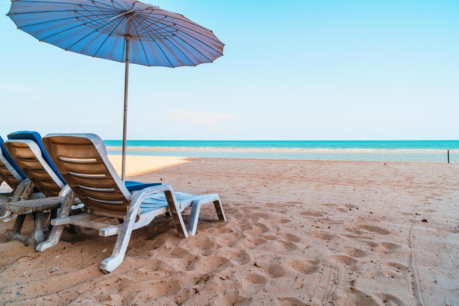 Empty beach chair on sand with ocean sea background photo