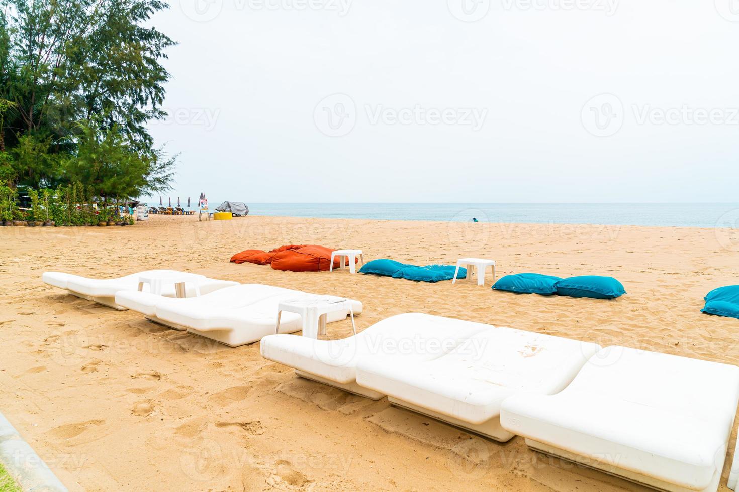 Empty beach chair on sand with ocean sea background photo