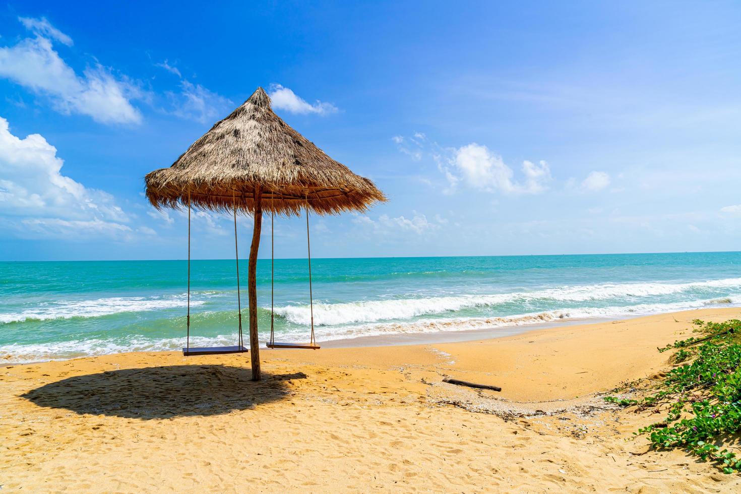 Swing on beach with ocean sea and blue sky background photo