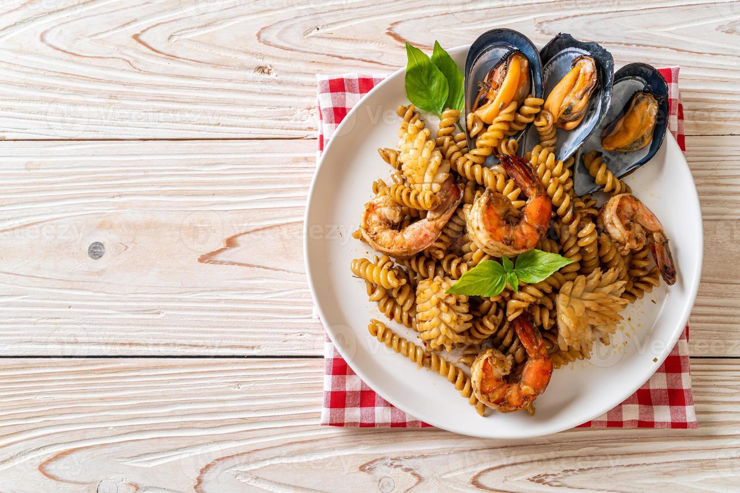 Stir-fried spiral pasta with seafood and basil sauce - fusion food style photo