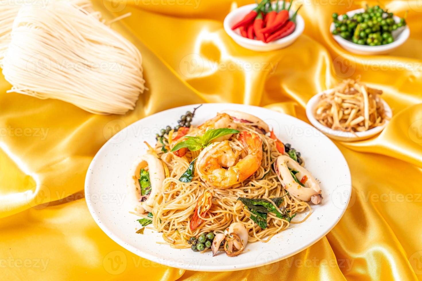 fideos chinos salteados con albahaca, chile, camarones y calamares - estilo de comida asiática foto