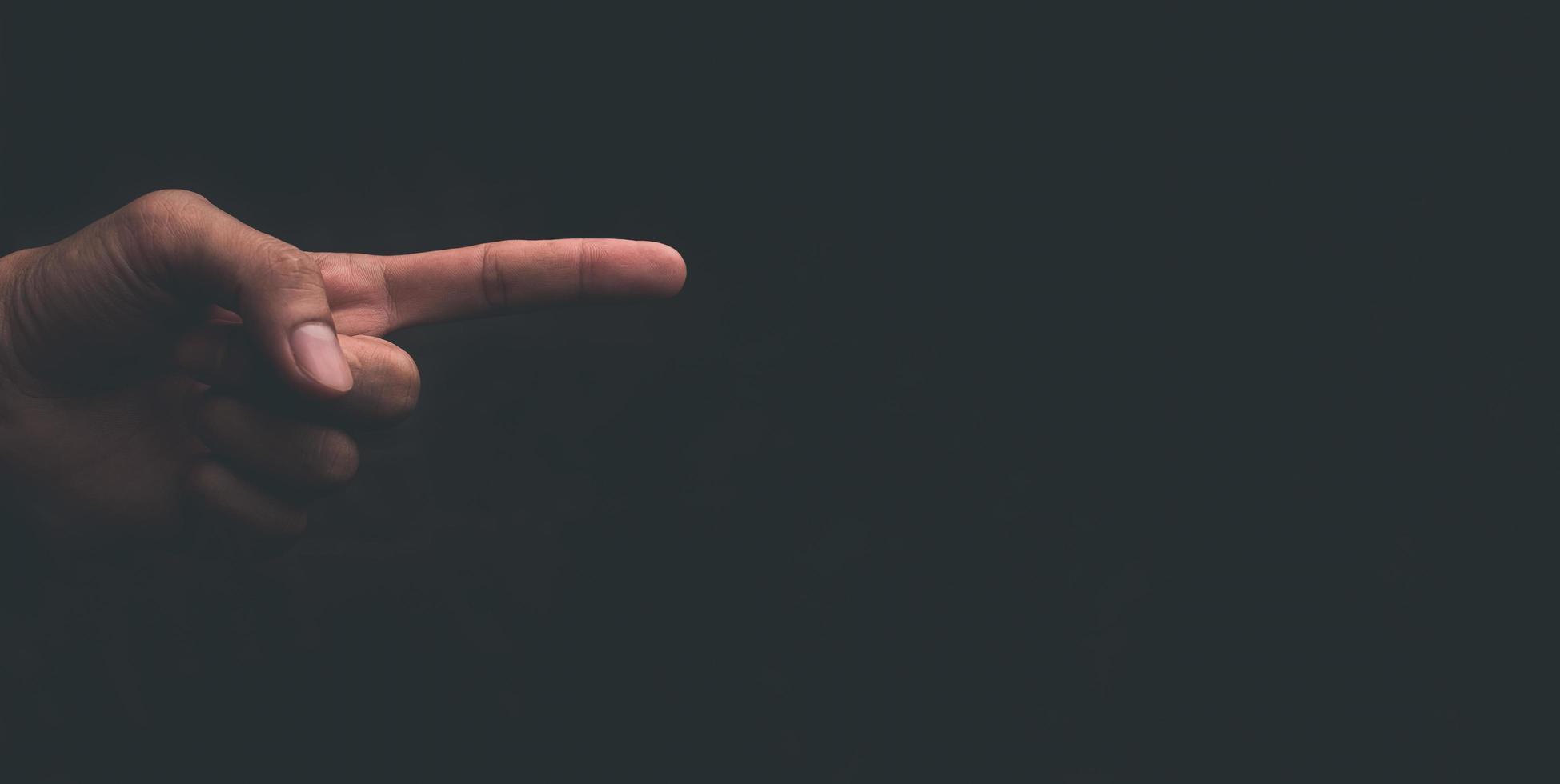 Man hand pointing finger on gray black background photo