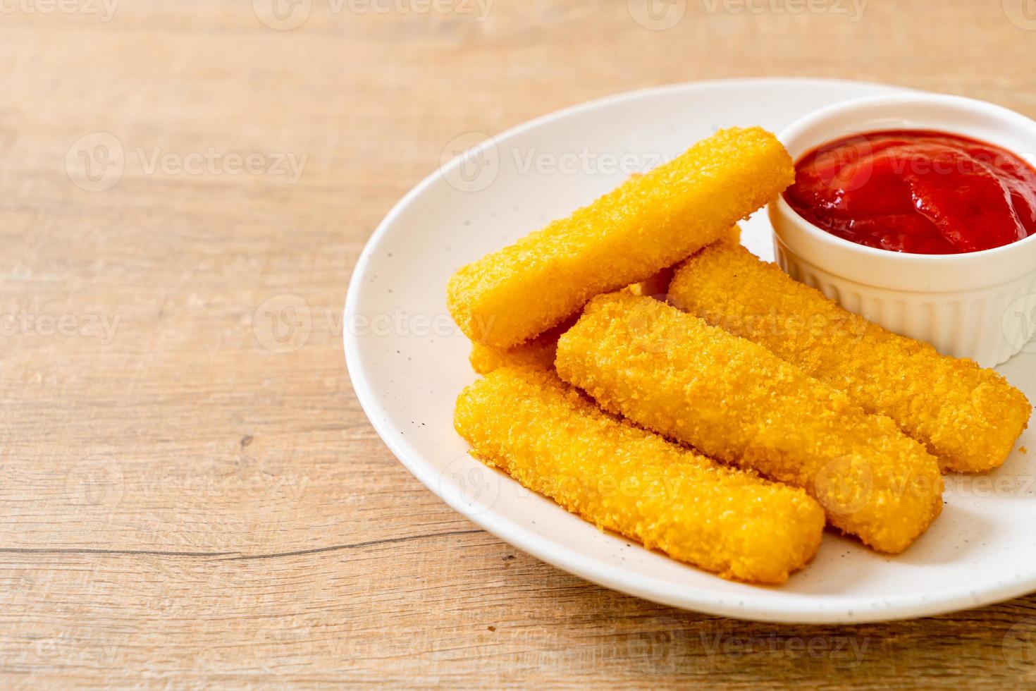 Crispy fried fish fingers with breadcrumbs served on plate with ketchup photo