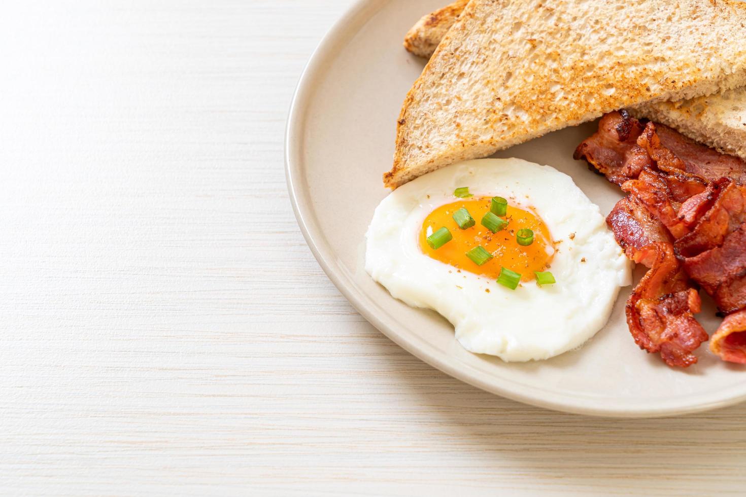 Fried egg with bread toasted and bacon for breakfast photo