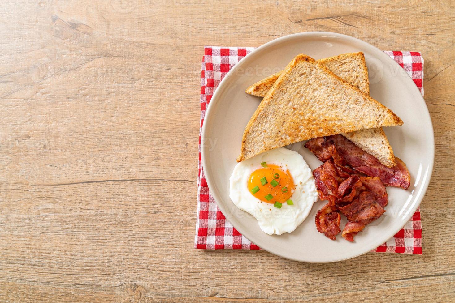 Fried egg with bread toasted and bacon for breakfast photo