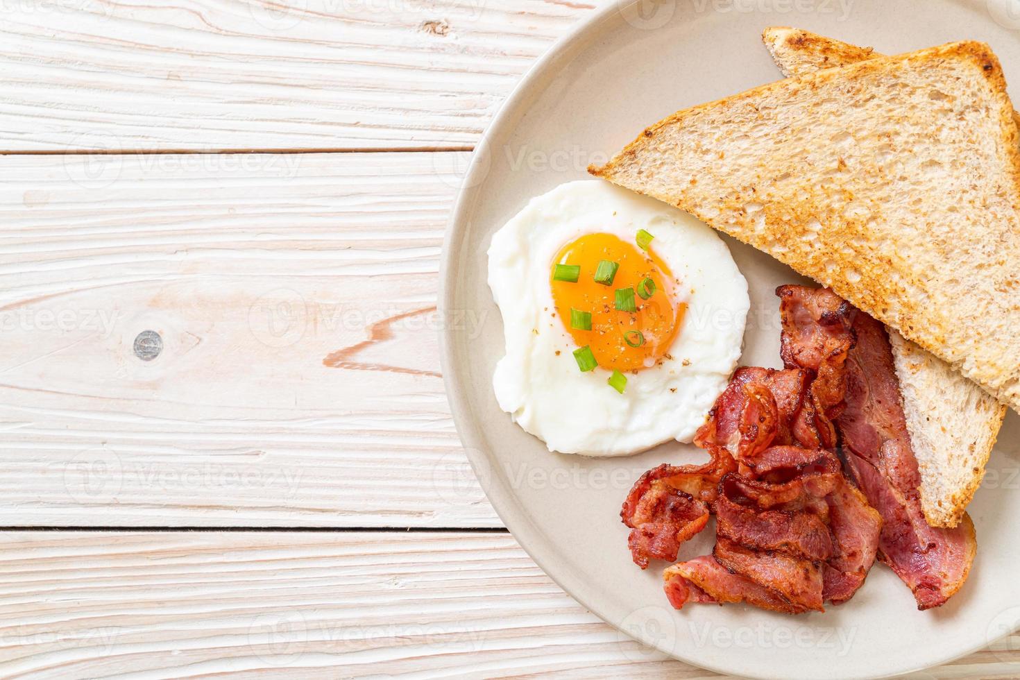 Fried egg with bread toasted and bacon for breakfast photo