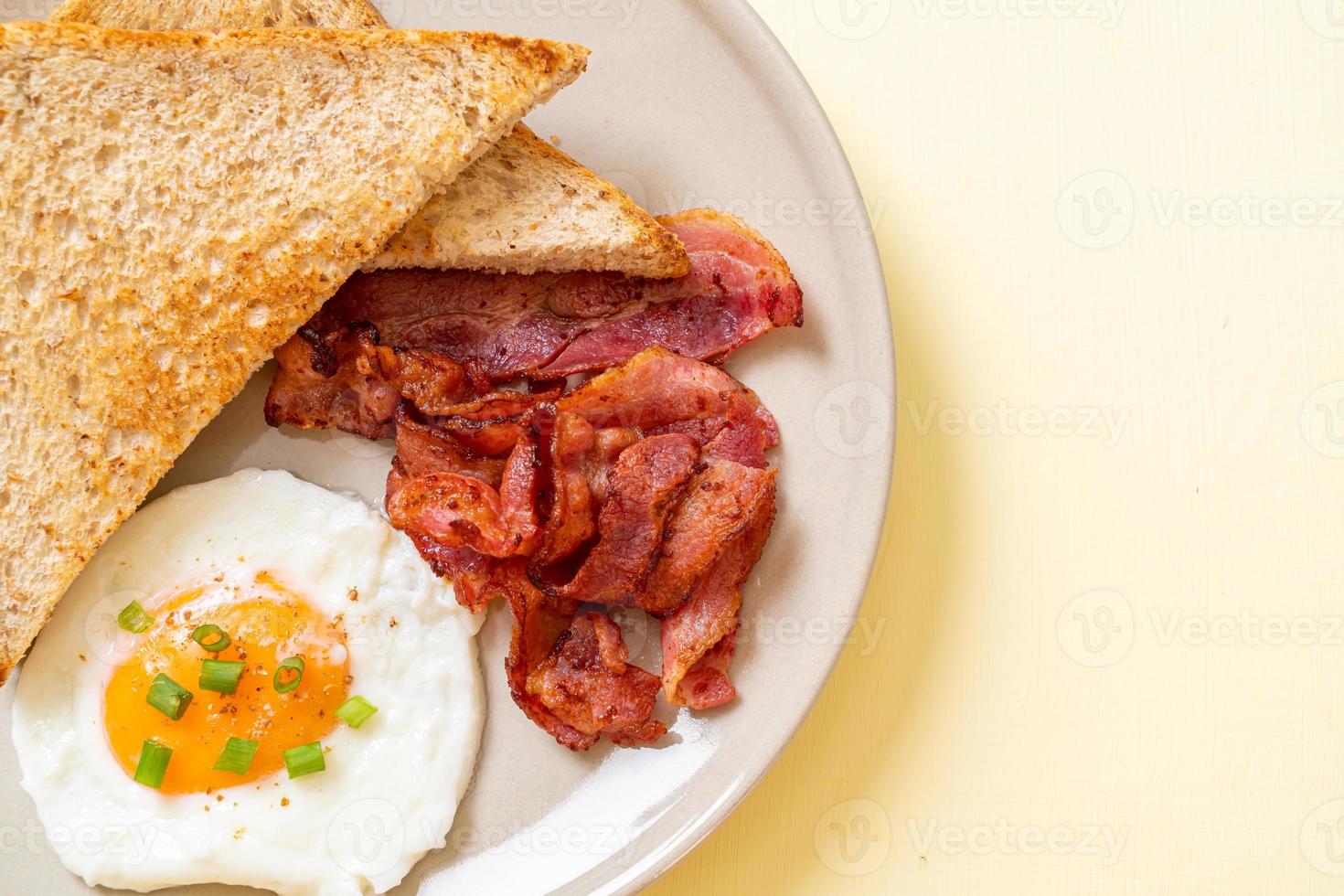 huevo frito con pan tostado y tocino para desayunar foto