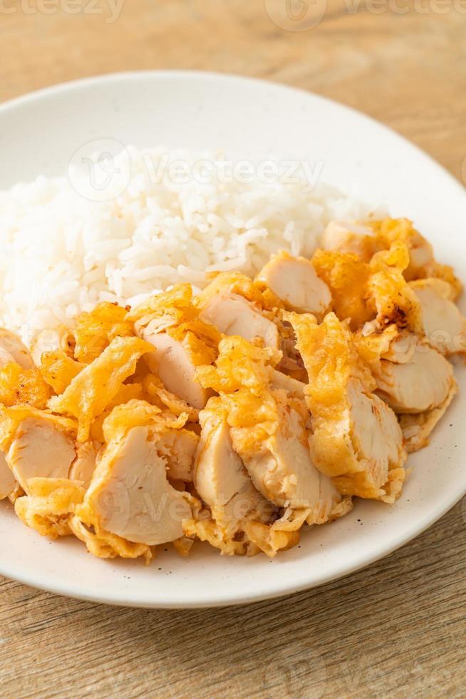 Fried chicken topped on rice with spicy dipping sauce photo