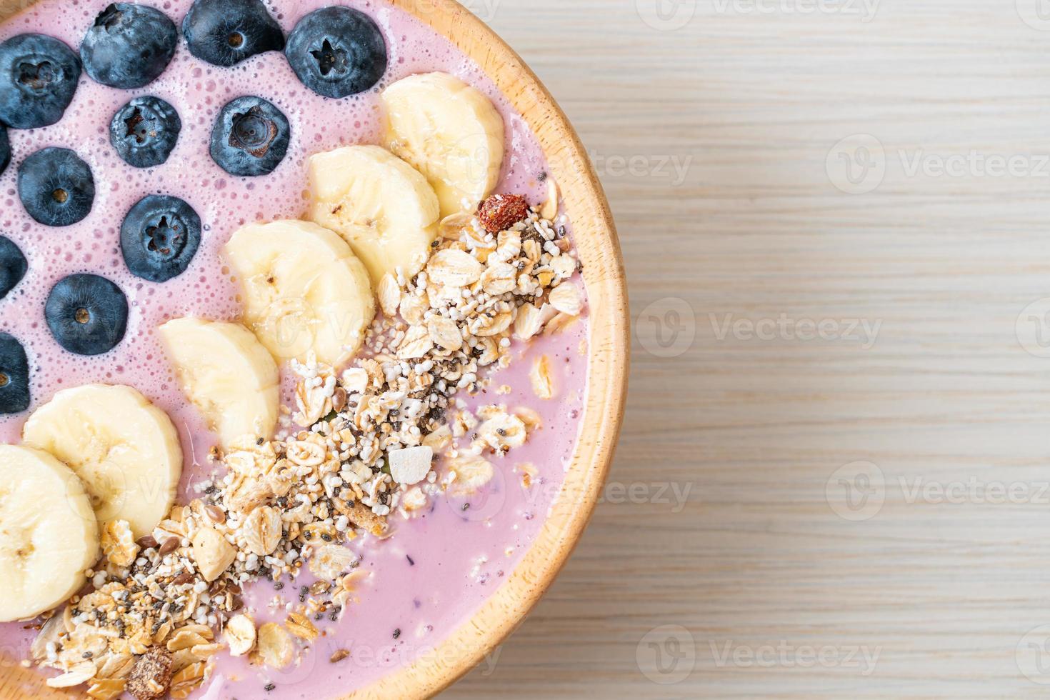 tazón de yogur o batido de yogur con bayas azules, plátano y granola foto