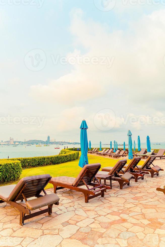 Piscina de silla o piscina de cama y sombrilla alrededor de la piscina con fondo de playa de mar en Pattaya en Tailandia foto