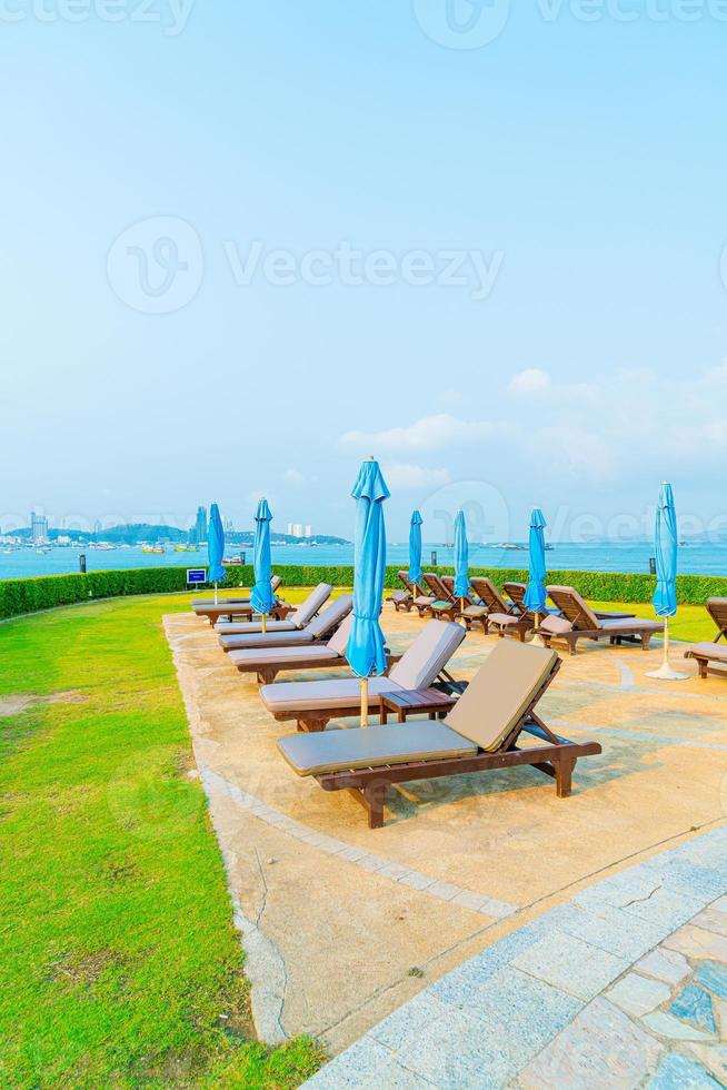Chair pool and umbrella around swimming pool with ocean sea background photo