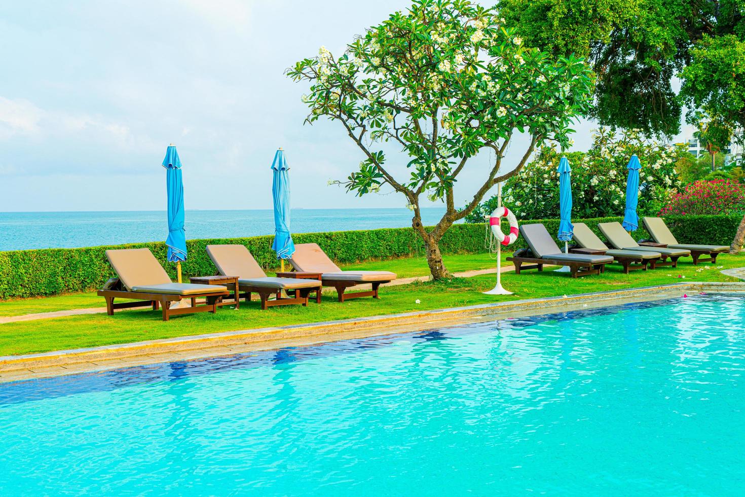 Chair pool and umbrella around swimming pool with ocean sea background photo